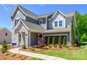 Stylish two-story home displaying a stone facade, well-manicured lawn and beautiful landscaping with a connecting walkway at 11024 Shreveport Dr, Huntersville, NC 28078