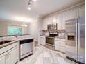 Bright kitchen with stainless steel appliances and white cabinets and tile floors at 12231 Stratfield Place Cir, Pineville, NC 28134