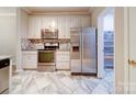 Bright kitchen with stainless steel appliances, white cabinets, and updated tile flooring at 12231 Stratfield Place Cir, Pineville, NC 28134