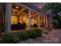 Inviting covered patio with outdoor seating, ceiling fans, brick fireplace, and a tranquil garden view at 1509 Churchill Downs Dr, Waxhaw, NC 28173