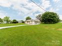 Sprawling lawn surrounds single-story home with attached carport and paved driveway at 2040 Stratford Dr, Conover, NC 28613