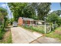 Cozy brick home with a driveway and a fenced front yard at 2217 Tate St, Charlotte, NC 28216