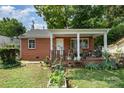 Charming brick home with a covered porch and small garden area at 2217 Tate St, Charlotte, NC 28216