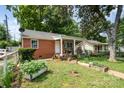 Quaint brick home with front yard including raised garden beds at 2217 Tate St, Charlotte, NC 28216
