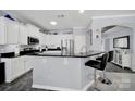 Kitchen featuring white cabinets, black countertops, stainless steel appliances, and a breakfast bar with seating at 2224 Hartwell Ln, Fort Mill, SC 29707