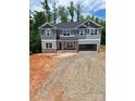 Two-story home with gray siding, stone accents, and attached two-car garage, surrounded by mature trees at 236 Mountain Island Rd # 40, Statesville, NC 28677