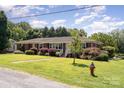 Charming one-story brick home with a lush green lawn and mature landscaping at 300 Caldwell St, Kannapolis, NC 28083