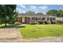 Charming one-story brick home with a lush green lawn and mature landscaping at 300 Caldwell St, Kannapolis, NC 28083