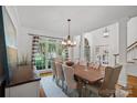 Elegant dining room with large windows, a wooden table with tufted chairs and bright natural light at 3506 Cardiff Ln, Matthews, NC 28104