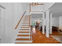 Bright foyer showcasing hardwood floors, staircase, open view to the living room and the beautiful stone fireplace at 3506 Cardiff Ln, Matthews, NC 28104