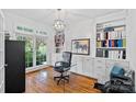 Stylish home office featuring custom built-ins, hardwood floors and a large sunny window at 3506 Cardiff Ln, Matthews, NC 28104
