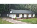 Stylish ranch home boasts white siding, dark trim, and a long driveway leading to the garage at 406 Wilcrest Dr, Matthews, NC 28105
