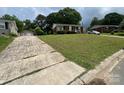 A charming brick home sits on a well-maintained lot with a detached two-car garage and long driveway at 4414 Birkdale Dr, Charlotte, NC 28208
