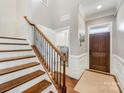 Elegant hallway featuring a staircase, wood floors, and a view of the laundry room at 5030 Waldron Meadow Dr, Charlotte, NC 28226