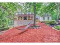 Backyard view of the two-story home, showing the deck and hammock amidst the trees at 5611 Charter Oaks Ln, York, SC 29745