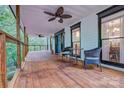 Covered porch with wooden floors and ceiling fans, furnished with chairs and a table at 5611 Charter Oaks Ln, York, SC 29745