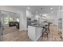 Open kitchen with white cabinets, black countertops, pendant lighting, and a spacious island at 6017 Sierra Dr, Charlotte, NC 28216
