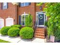 Inviting entrance showcases a wreath on the front door, manicured bushes, and brick steps at 701 Larkridge Ct, Rock Hill, SC 29730