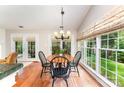 Sunny breakfast area with large windows, hardwood floors, and a charming chandelier at 7211 Baniff Cir, Charlotte, NC 28277