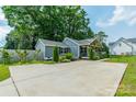 View of the gray home with a long concrete driveway and well-manicured landscaping at 7901 Reames Rd, Charlotte, NC 28216