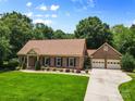 Beautiful brick home featuring a well-manicured lawn, a driveway, and an attached two-car garage at 7916 Wellston Dr, Charlotte, NC 28210