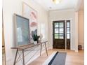 Inviting entryway with wood floors, stylish console table, modern art, and an elegant wooden door at 7930 Rolling Wheels Rd, Charlotte, NC 28215