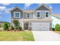 Charming two-story home featuring gray siding, a two-car garage, and a well-maintained front lawn at 7930 Rolling Wheels Rd, Charlotte, NC 28215