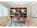 Bright home office with custom built-in shelving, modern desk, and large window for natural light at 7930 Rolling Wheels Rd, Charlotte, NC 28215