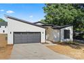 Modern home exterior featuring a sleek garage door, black trim, and minimalist landscaping at 8632 Cedarbrook Dr, Charlotte, NC 28215