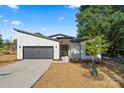 Bright modern home exterior with black trim, sleek garage door, and a well-manicured lawn at 8632 Cedarbrook Dr, Charlotte, NC 28215
