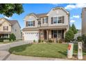 Beautiful two-story home with a well-manicured lawn, stone accents, and a two-car garage at 112 Artisan Ct, Mooresville, NC 28117
