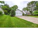 Well-maintained home exterior with a long driveway leading to an attached two-car garage and mature trees at 1506 Cameron Dr, Statesville, NC 28625