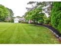 Beautifully landscaped front yard with a lush green lawn and mature shade tree at 1506 Cameron Dr, Statesville, NC 28625