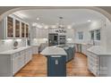 Modern kitchen with white cabinetry, stainless steel appliances, a large center island and stylish pendant lighting at 2006 Sandy Pond Ln, Waxhaw, NC 28173