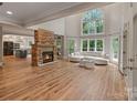Bright living room featuring a stone fireplace, large windows, and access to the deck overlooking the backyard at 2006 Sandy Pond Ln, Waxhaw, NC 28173