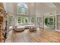 Bright living room featuring soaring ceilings, a fireplace, hardwood floors and large windows offering plentiful natural light at 2006 Sandy Pond Ln, Waxhaw, NC 28173