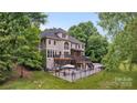 Expansive back of house view shows a large deck, patio, and lush greenery at 2006 Sandy Pond Ln, Waxhaw, NC 28173