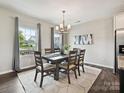 Bright dining room featuring a stylish chandelier, a modern table, and large windows at 2017 New Hope Branch Way, Belmont, NC 28012