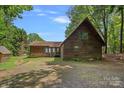 Charming wood home featuring a peaked roof, green-trimmed windows, and large gravel parking at 2563 Brawley School Rd, Mooresville, NC 28117
