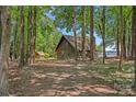Cozy cabin-style home nestled among trees, with a glimpse of the lake in the background at 2563 Brawley School Rd, Mooresville, NC 28117
