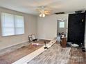 Bright living room featuring a ceiling fan and a brick fireplace, with floors partially updated and windows at 2791 Neill Rd, Lancaster, SC 29720