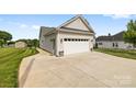 Side view of the house features a detached two car garage with a concrete driveway and landscaping at 2996 N Lookout St, Claremont, NC 28610