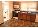 An efficiently designed kitchen with wooden cabinets, standard appliances, and a stainless steel sink at 327 Bonview Ave, Lincolnton, NC 28092