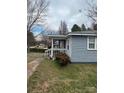 View of home's side with weathered siding and trimmed bushes at 341 Talley St, Troutman, NC 28166