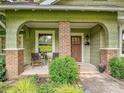 Inviting covered front porch with brick supports, seating area, and a view of the front yard at 3459 Selwyn Ave, Charlotte, NC 28209