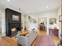 Bright living room with hardwood floors, a black fireplace, and an open doorway to the dining room at 3459 Selwyn Ave, Charlotte, NC 28209