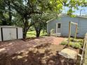 View of the home's backyard with paver patio and exterior storage building at 408 N Hill St, Dallas, NC 28034