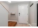Clean, modern entryway with a white door, tile flooring, and a convenient coat rack at 4124 Melrose Club Dr, Matthews, NC 28105