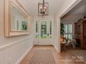 Bright foyer with hardwood floors, paneled walls, a decorative mirror and modern light fixture at 4201 Quail Hunt Ln, Charlotte, NC 28226