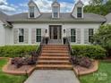 Inviting front entrance with brick stairs, iron railings, and a glass paneled front door at 4201 Quail Hunt Ln, Charlotte, NC 28226